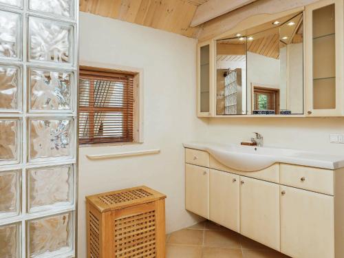 a bathroom with a sink and a mirror at Holiday Home Fyrrealle in Nørby