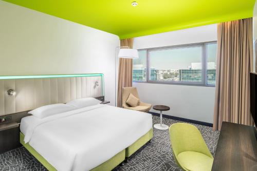 a hotel room with a bed and a desk and chair at Park Inn by Radisson, Riyadh in Riyadh