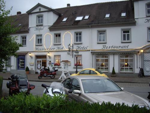 un coche aparcado frente a un edificio blanco en Hessischer Hof, en Bad Karlshafen
