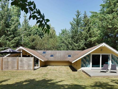 a house with two chairs sitting on a lawn at 8 person holiday home in Aakirkeby in Vester Sømarken