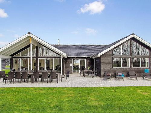 a house with tables and chairs in front of it at 18 person holiday home in Hasselberg in Kappeln