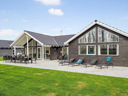 a house with chairs and tables in front of it at 18 person holiday home in Hasselberg in Kappeln