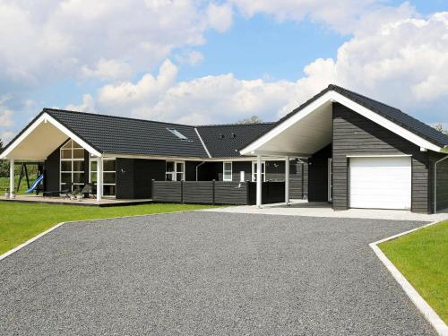 uma casa com um telhado preto e uma entrada em 8 person holiday home in Hadsund em Hadsund