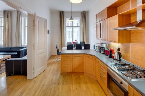 布拉格的住宿－Kaprova 5 - Old Town Apartments，厨房配有木制橱柜和炉灶烤箱。