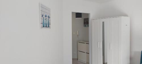 Zimmer mit einem weißen Schrank und einem Schrank in der Unterkunft Apartament 4YOU in Pobierowo