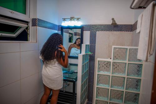 a woman taking a picture of herself in a bathroom mirror at Ocean's Edge Lodge Restaurant & Bar in Roseau