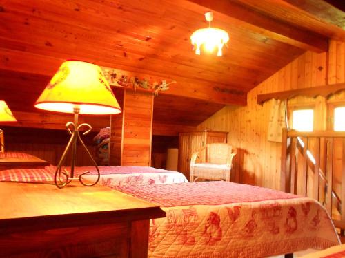 a bedroom with two beds and a lamp in a cabin at Cosy chalet with garden in Notre-Dame-de-Bellecombe