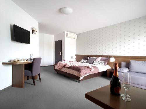 sypialnia z łóżkiem, kanapą i stołem w obiekcie Hotel Willowa w mieście Lublin
