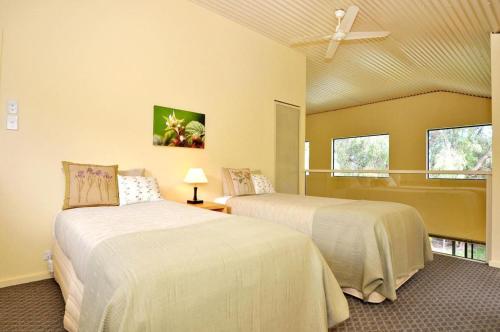 a bedroom with two beds and a ceiling fan at Tree Elle Retreat in Bow Bridge