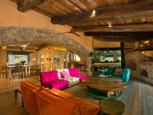 un soggiorno con mobili rosa e blu e un camino in pietra di Belvilla by OYO Villa Mezzeria a Guardea