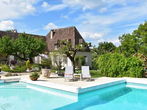 - une piscine en face d'une maison avec 2 chaises dans l'établissement Luxurious Mansion in Aquitaine with Swimming Pool, à Port-Sainte-Foy-et-Ponchapt