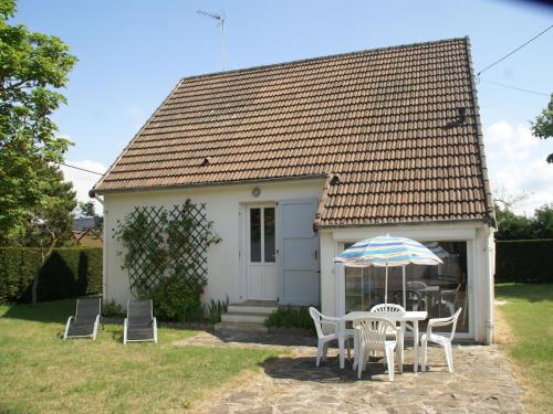 サン・ジェルマン・シュル・エにあるBeautiful holiday home with gardenの小さな白い家(テーブル、椅子、傘付)