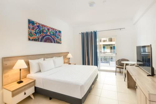 a hotel room with a bed and a tv at Decameron La Marina Guayabitos, Ramada All-Inclusive Resort in Rincon de Guayabitos