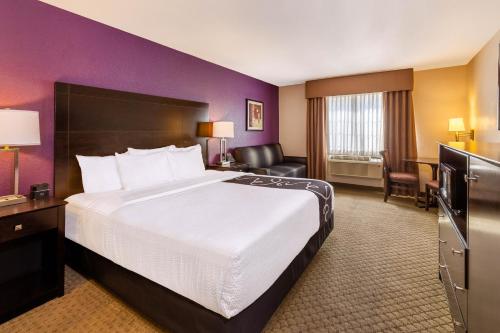 una habitación de hotel con una gran cama blanca y paredes moradas en La Quinta by Wyndham Spokane Valley, en Spokane Valley