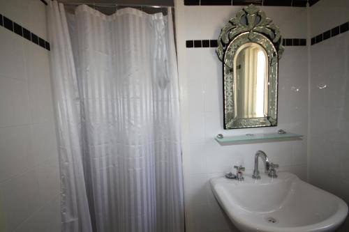 a bathroom with a sink and a shower curtain at Bourke Riverside Motel in Bourke