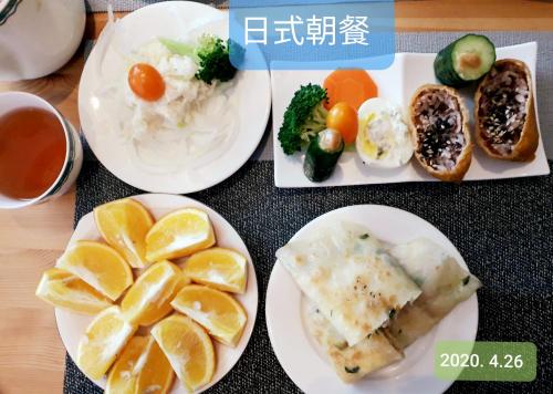 Foresweet B&B في هنغتشون أولد تاون: طاولة مع أطباق من الطعام مع البرتقال والخضار