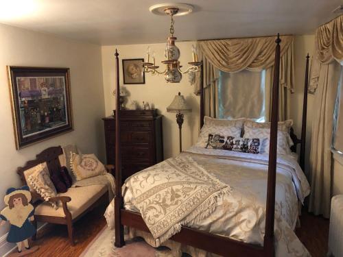a bedroom with a bed and a chair and a window at Angies B&B in Wilmington