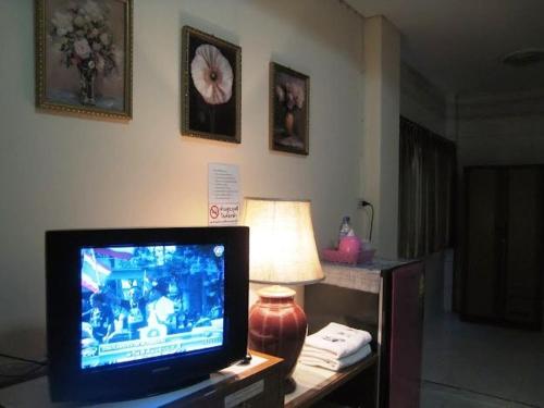 un televisor sentado en una mesa junto a una lámpara en Choktawee Mansion Lampang, en Lampang
