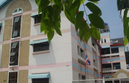 un edificio alto con hojas verdes delante de él en Choktawee Mansion Lampang, en Lampang