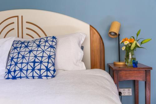 um quarto com uma cama e um vaso de flores sobre uma mesa em Blue moon em Collingwood