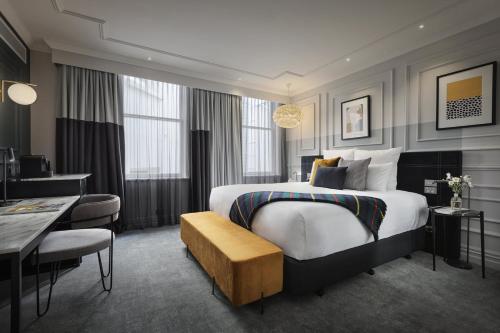 a hotel room with a large bed and a desk at Fable Dunedin in Dunedin