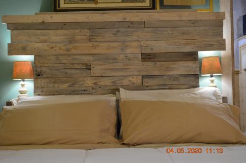 a bed with two pillows and a wooden headboard at Villa Dacia in Guiglia