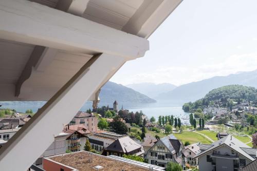 a view from a balcony of a town with a lake at la belle vue Boutique Hotel & Café in Spiez
