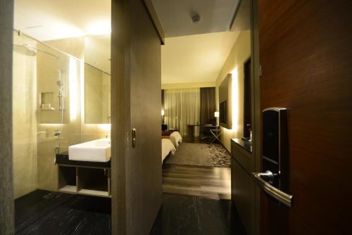 a bathroom with a sink and a bed in a room at The Light Hotel Penang in Perai