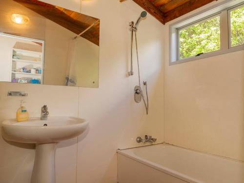 a bathroom with a sink and a bath tub at Hahei Hideaway - Hahei Holiday Home in Hahei