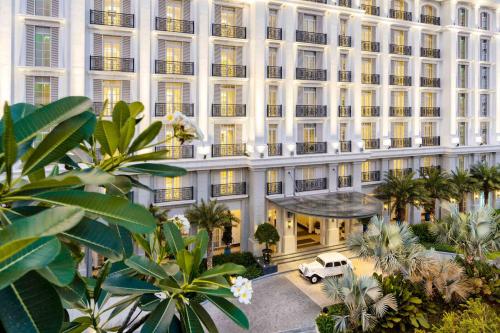 an exterior view of a hotel with a white truck parked in front at Mia Saigon – Luxury Boutique Hotel in Ho Chi Minh City