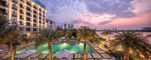 a view of a hotel with a pool and palm trees at Mia Saigon – Luxury Boutique Hotel in Ho Chi Minh City