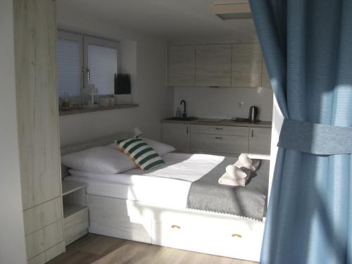 a small bedroom with a bed and a kitchen at Surf camp in Krynica Morska