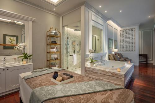 a large bathroom with a tub and a large bed at Mia Saigon – Luxury Boutique Hotel in Ho Chi Minh City