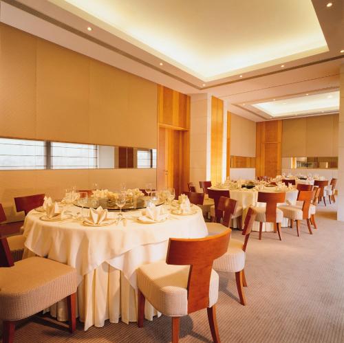 een eetkamer met witte tafels en stoelen bij Rambler Oasis Hotel in Hong Kong