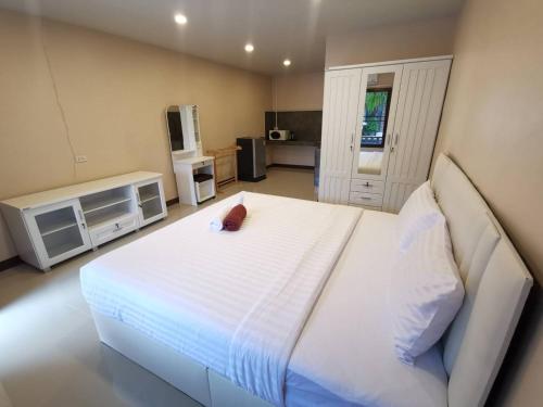 um quarto com uma grande cama branca e uma televisão em The Passion Nest - SHA Plus Certified em Phuket