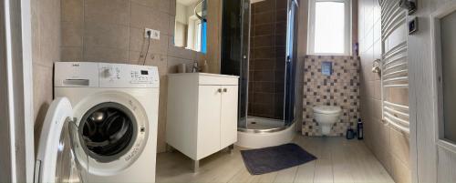 a bathroom with a washing machine and a toilet at Apartmán Pod Klinom in Pribylina
