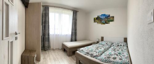 a small bedroom with a bed and a window at Apartmán Pod Klinom in Pribylina