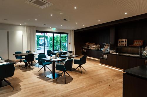 a restaurant with tables and chairs in a room at Hotel Messmer in Bregenz