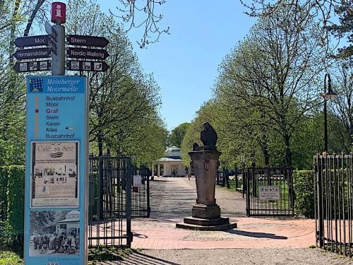 a sign in front of a gate with a statue at Gästehaus am Kurpark Hotel Garni in Horn-Bad Meinberg