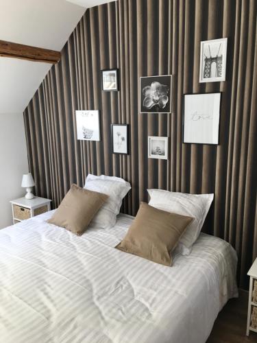 a bedroom with a large bed with pictures on the wall at La Halte Effervescente in Épernay
