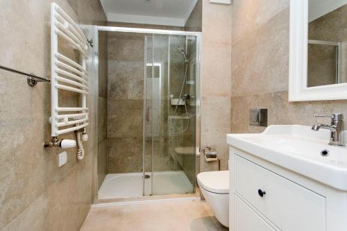 a bathroom with a shower and a toilet and a sink at Vanilla Rentyear Apartments in Gdańsk