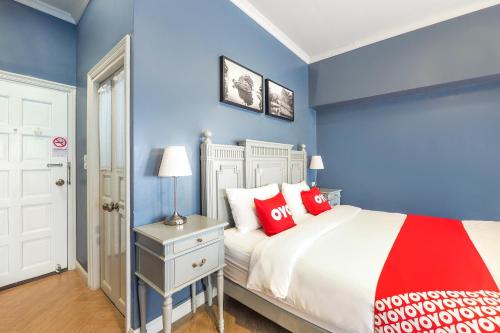 um quarto com paredes azuis e uma cama com almofadas vermelhas em OYO 899 Villa De Hun em Chiang Mai