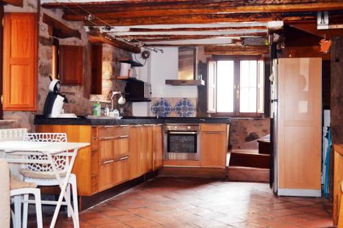 una cocina con armarios de madera y una mesa. en La Casita Del Rincón Del Vino, en Ezcaray