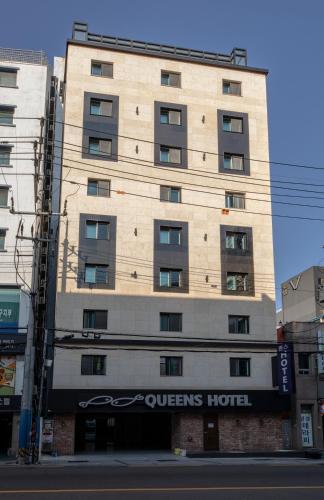 a tall building with a queens hotel sign on it at Queens Hotel Seomyeon Busan in Busan