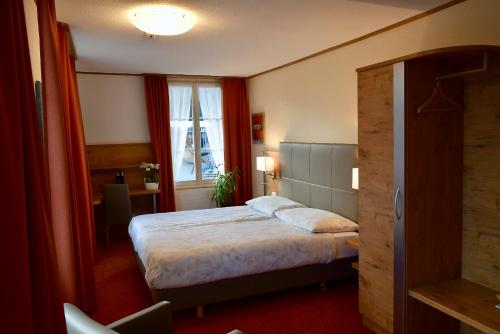 une chambre d'hôtel avec un lit et une fenêtre dans l'établissement Hotel Emmental, à Langnau im Emmental