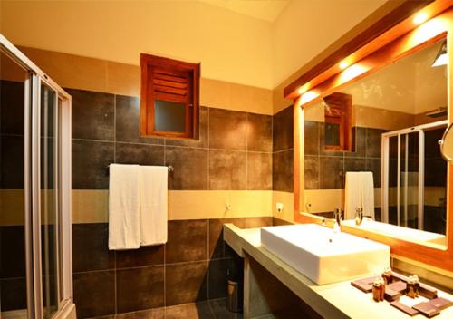 een badkamer met een wastafel en een spiegel bij Laya Waves in Pasikuda