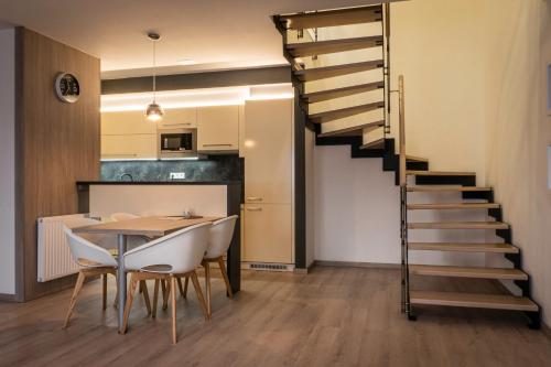 a dining room with a table and a spiral staircase at Apartmány Zámek - Vimperk in Vimperk