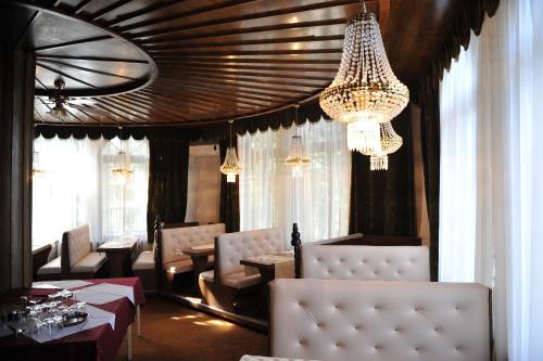 a dining room with a chandelier and tables and chairs at B&B Villa Pipacs in Feketić