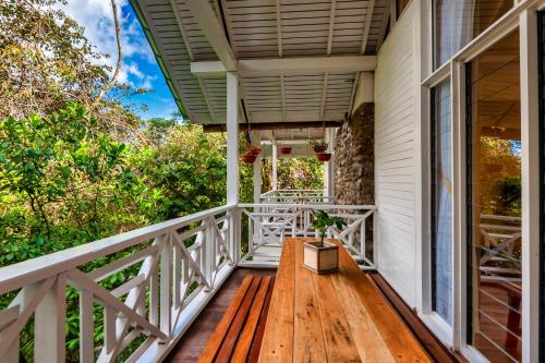 a porch with a wooden bench on a house at Sutera Sanctuary Lodges At Kinabalu Park in Kundasang