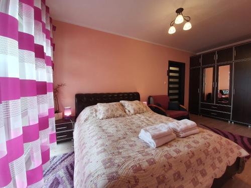 a bedroom with a bed with pink and purple walls at Apartament w Porcie - 365PAM in Kołobrzeg